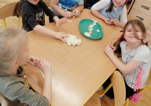 Dzieci wykonują szkielet dinozaura z masy solnej.