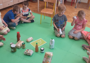 Dzieci na produktach poszukują znaczka oznaczającego żywność ekologiczną