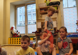 Dzieci siedzą w kole i bawią się w zabawę "Mam chusteczkę"