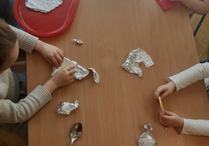 Dzieci przy stoliku poznają różnorodne materiały