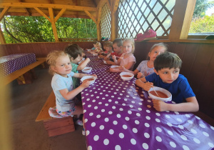 Dzieci przy stoliku jedzą zupę