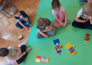 Dzieci na podłodze układają swoje roboty