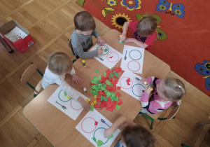 Dzieci wyklejają papierem sygnalizator świetlny,