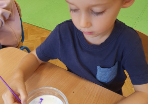 Dzieci mieszają kolorowe barwniki w mleku