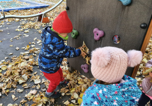 Dzieci bawią się jesiennymi liśćmi