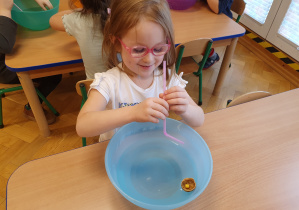 Ćwiczenia oddechowe- dzieci za pomocą słomki robią duże fale w misce z wodą, w której pływa pianka w skorupce od orzecha.