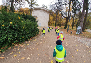Na zdjęciu widać dzieci spacerujące alejkami w parku