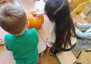 Dzieci sprawdzają co mieści się w środku dyni