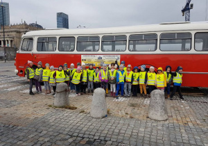 Dzieci stoją obok zabytkowego autobusu 