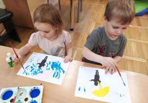 Dzieci farbami malują deszcz.