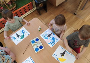 Dzieci malują niebieską farbą.