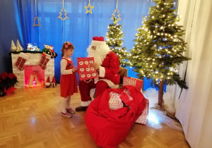 Mikołaj wręcza dziewczynce prezent