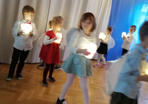 Dzieci idą w kole i tańczą z lampionami
