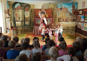 Dzieci tańczą z aktorami w kole na scenie