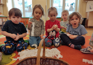 Dzieci robią kuleczki z krepiny.