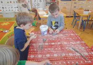 Dzieci przy stoliku lepią z gliny