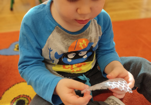 Chłopiec bawi się folią bąbelkową.