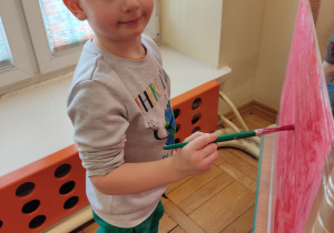 Chłopiec maluje na folii.