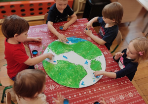 Dzieci wykonują makietę planety Ziemi.