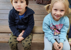Chłopiec i dziewczynka siedzą na ławce.