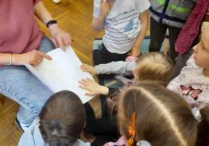 Dzieci poznają książkę napisaną alfabetem Braille'a