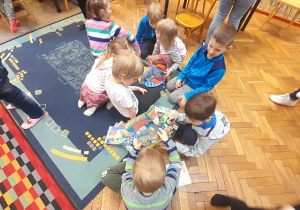 Dzieci na dywanie oglądają komiksy