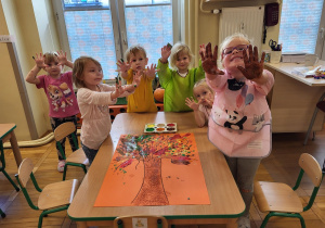 Dzieci pokazują brudne rączki od farby.