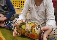 Na zdjęciu dziecko trzyma słoik z zawekowanymi warzywami.