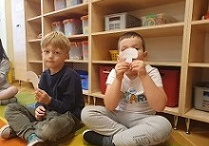 Dzieci trzymają w ręku wycięte z papieru grzybki z imionami.
