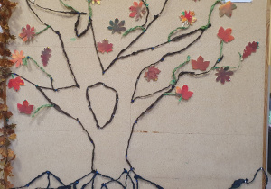 Na zdjęciu widać drzewo ułożone z sznureczków krepiny i ozdobione namalowanymi w kolorach jesieni liśćmi