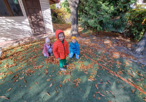 Na zdjęciu widać dzieci wśród jesiennych liści.