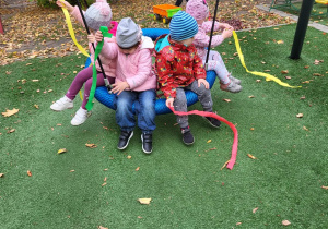 Dzieci huśtają się na bujawce.