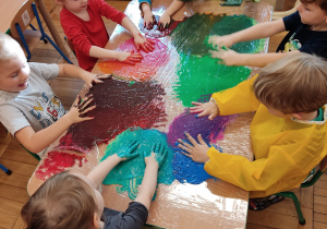 Dzieci malują farbą.