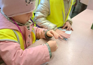 Dzieci naklejają znaczki pocztowe na kopertach
