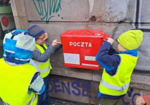 Dzieci wrzucają listy do skrzynki pocztowej