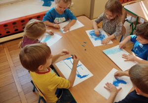 Dzieci malują pastelami kartki.