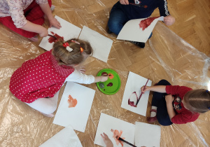 Dzieci tworzą obrazek za pomocą farb.