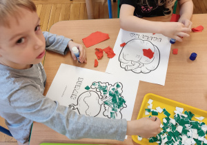 Dzieci wyklejają warzywa kolorowym papierem.