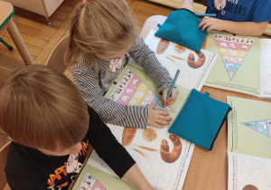 Dzieci wykonują zadanie w książce.