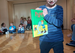 Chłopiec prezentuje wybrana książkę.