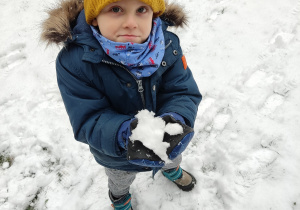 Chłopiec trzyma śnieg.