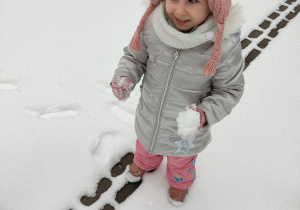 Dziewczynka robi śnieżkę.