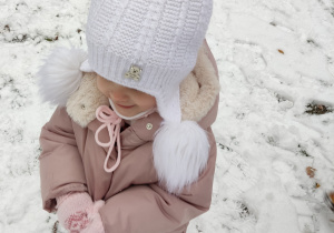Dziewczynka trzyma śnieg.