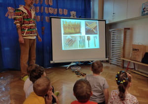 Dzieci oglądają zdjęcia na prezentacji.