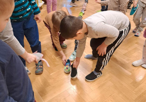 Dzieci układają kolejno buty.