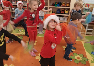 Dzieci tańczą taniec swobodny dla Mikołaja.