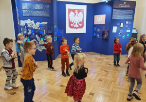 Na zdjęciu widać dzieci biorące udział w zabawie ruchowej w muzeum.