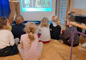 Na zdjęciu dzieci oglądają prezentację na temat rzeźby.