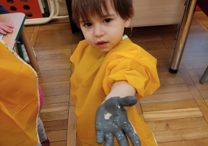 Chłopiec pokazuje rękę w farbie.