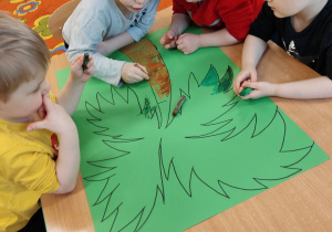 Dzieci kolorują pastelami palmę.